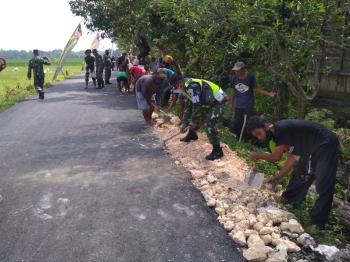 Anggota Satgas TMMD Bojonegoro Gotong Royong Bareng Warga Timbun Tepi Aspal